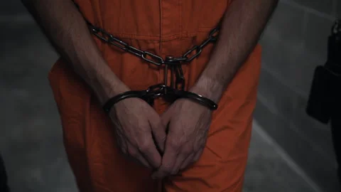Hands of prison inmate in handcuffs, handcuffed in shackles, arrested for Stock Footage 244303057