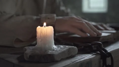 Hands of a prisoner locked in shackles tracing lines in a book, camera moving 스톡 동영상 340322824