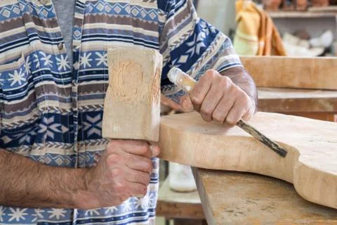 Hands processing wood with a chisel Stock Photos