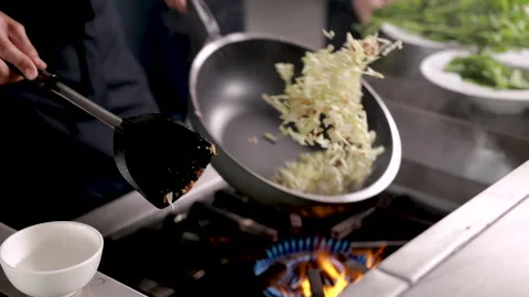 Hands of professional chef working in restaurant holding hot frying pan coo.. Stock Footage 245484366