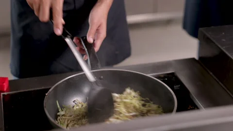 Hands of professional chef working in restaurant holding hot frying pan coo.. Stock Footage 245496153