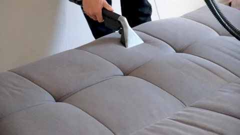 Hands of professional cleaner removing dirt from sofa using vacuum cleaner. Video stock 311799660