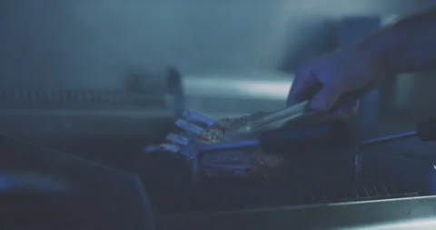 Hands of professional cook turning meat on the grill Stock Footage 203556474
