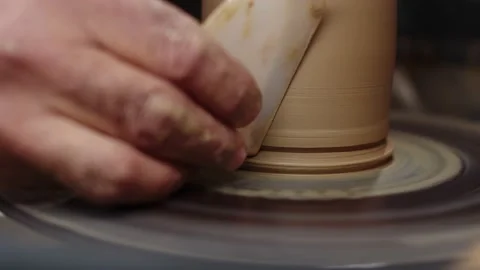 Hands of professional potter form clay jug with special scraper on potter's Stock Footage 160154574