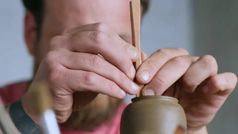 Hands of a professional potter shaping a clay product on a potter's wheel Stock Footage 145534601