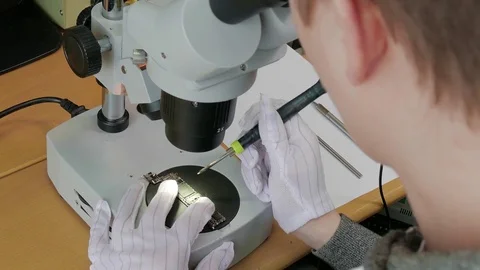 Hands of professional tech repairing small computer components on microscope Stock Footage 76625740