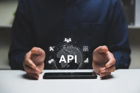 Hands of programmer and smartphone with API or Application Program Interface 库存照片
