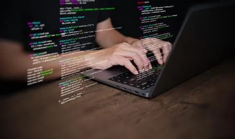 Hands of a programmer types on a laptop displaying programming code, symbol.. Stockfoto's