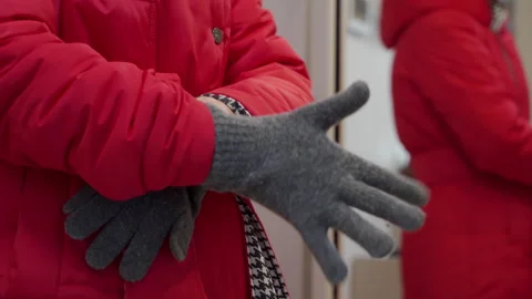 Hands Protected: Grey Knit Glove Slides Over Red Jacket with a Soft Rustle Video stock 320808978