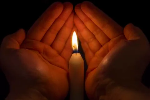 Hands protecting a candle Stock Photos