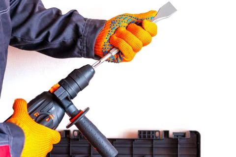 Hands in protective gloves, hammer drill, chisel, bit, Stock Photos