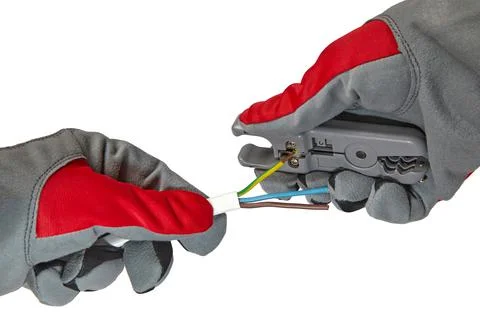 Hands in protective gloves with a stripper and an electric cable isolated on a Stock Photos