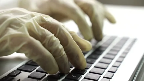 Hands in protective gloves type on the laptop Stock Footage