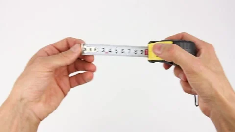 Hands pull measuring tape out of tape measure and measure, white background Видео 135290790