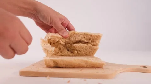 Hands Pulling Apart Fresh Sliced Focaccia Bread on Wooden Board Stock Footage 337689683
