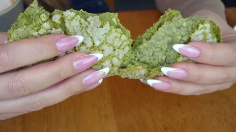 Hands Pulling Apart Matcha Cream Filled Pastry in Close Up Stock Footage 341777326