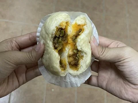Hands Pulling Apart Steamed Bun With Spicy Petai Bean Filling Stock Photos