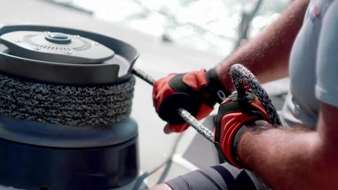 Hands pulling a rope in the grip of a sailboat Stock Footage 262254843