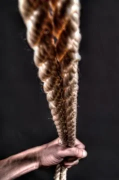 Hands pulling rope over dark background Foto stock