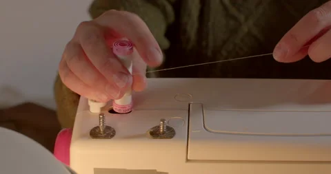 Hands pulling thread sewing machine She pulls white thread puts into device Stock Footage 195705905