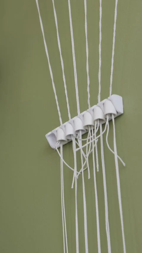 Hands Pulling White String From Wall Mounted Mechanical Organizer Video stock 329682537