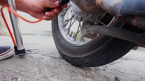 Hands pump air into motorcycle tire Stock Footage 81144925