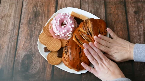 Hands push away sweets plate with buns, candies and donut Stock Footage 124738928