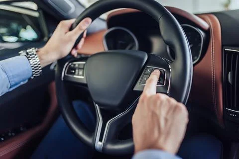 Hands pushing button on the steering wheel Stock Photos