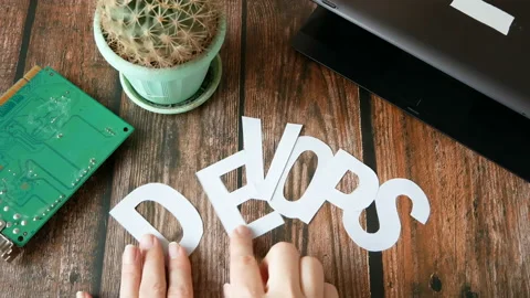 Hands put on board words Dev and Ops. DevOps Concept for software engineering Stock Footage 132089913