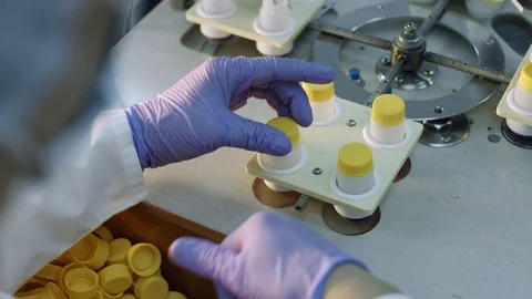 Hands put the cap on the bottle, medical production Stock Footage 101013773