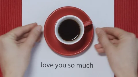 Hands put coffee in red mug on table with Valentine's postcard . Top view, love. 스톡 동영상 121518780