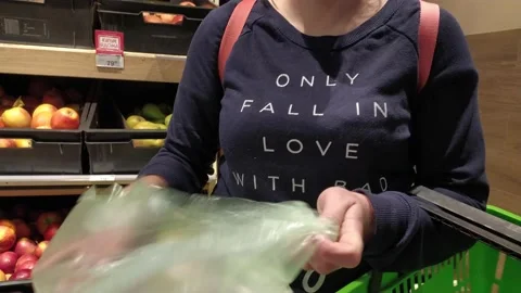 Hands put fresh cucumbers in a plastic bag. basket for groceries Stock Footage 131108104