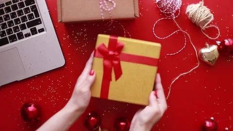 Hands put a gift on the table. Flat lay christmas on red background Stock Footage 245205354