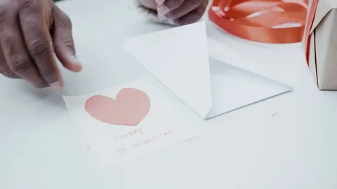 Hands put heart postcard in envelope for beloved couple for valentines with love Stock Footage 100001352