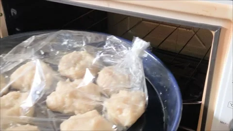 Hands put the pan with the cutlets in the oven Video stock 311843745