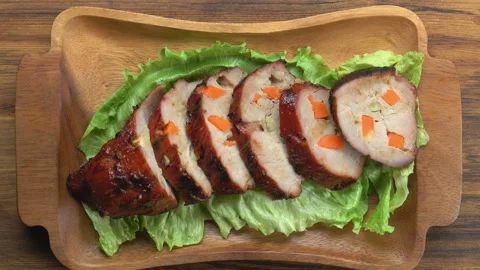 Hands put a plate with cut meatloaf and lettuce leaves on the table Stock Footage 234137012