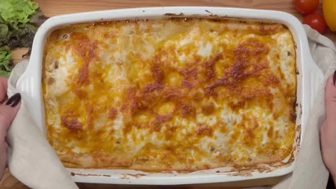 Hands put a plate with ready appetizing lasagna Stock Footage 293131010