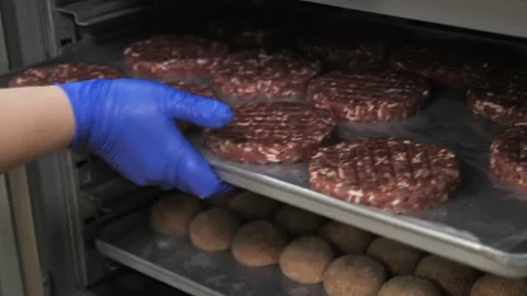Hands put a tray with meat marbled beef cutlets beef burger into freezer. Video stock 148050103