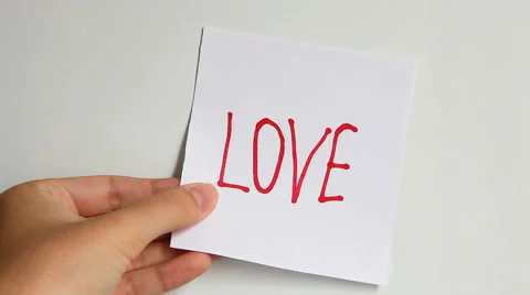 Hands put words: Guess what? Love! on the white background Vídeos de archivo 65340388