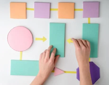 Hands putting arrows between blocks on white background Stock Photos
