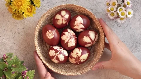 Hands putting a basket with handmade Easter eggs onto a table Stock Footage 241110170
