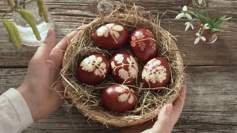 Hands putting a basket with homemade Easter eggs onto a table Stock Footage 170397889
