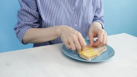 Hands putting cheese on bread on kitchen table, cutting fresh ingredients f.. Stock Footage 303803674