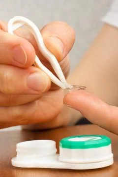 Hands putting on contact lenses Stock Photos