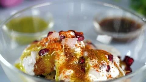 Hands putting dry roasted Masala in a bowl of Tikkis, pomegranate, and Dahi -... Stock Footage 157254083