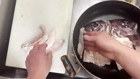 Hands Putting Fish Heads and Bones into a Pan (Sea Bream), Japanese Food Stock Footage 340930836