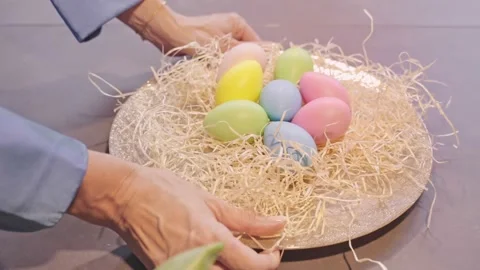 Hands putting Nest with Easter Eggs on the Table Stock Footage 236341744