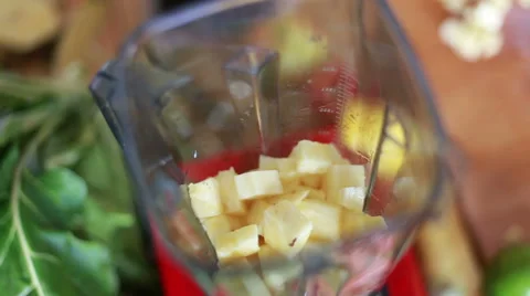Hands putting pieces of pineapple in blender Stock Footage 59540453