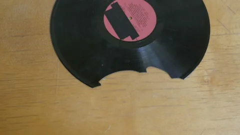 Hands putting pieces together of broken vinyl record Stock Footage 106052083