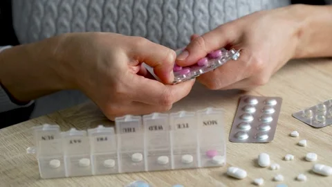 Hands putting pills into pill box, close-up Stock Footage 260821054
